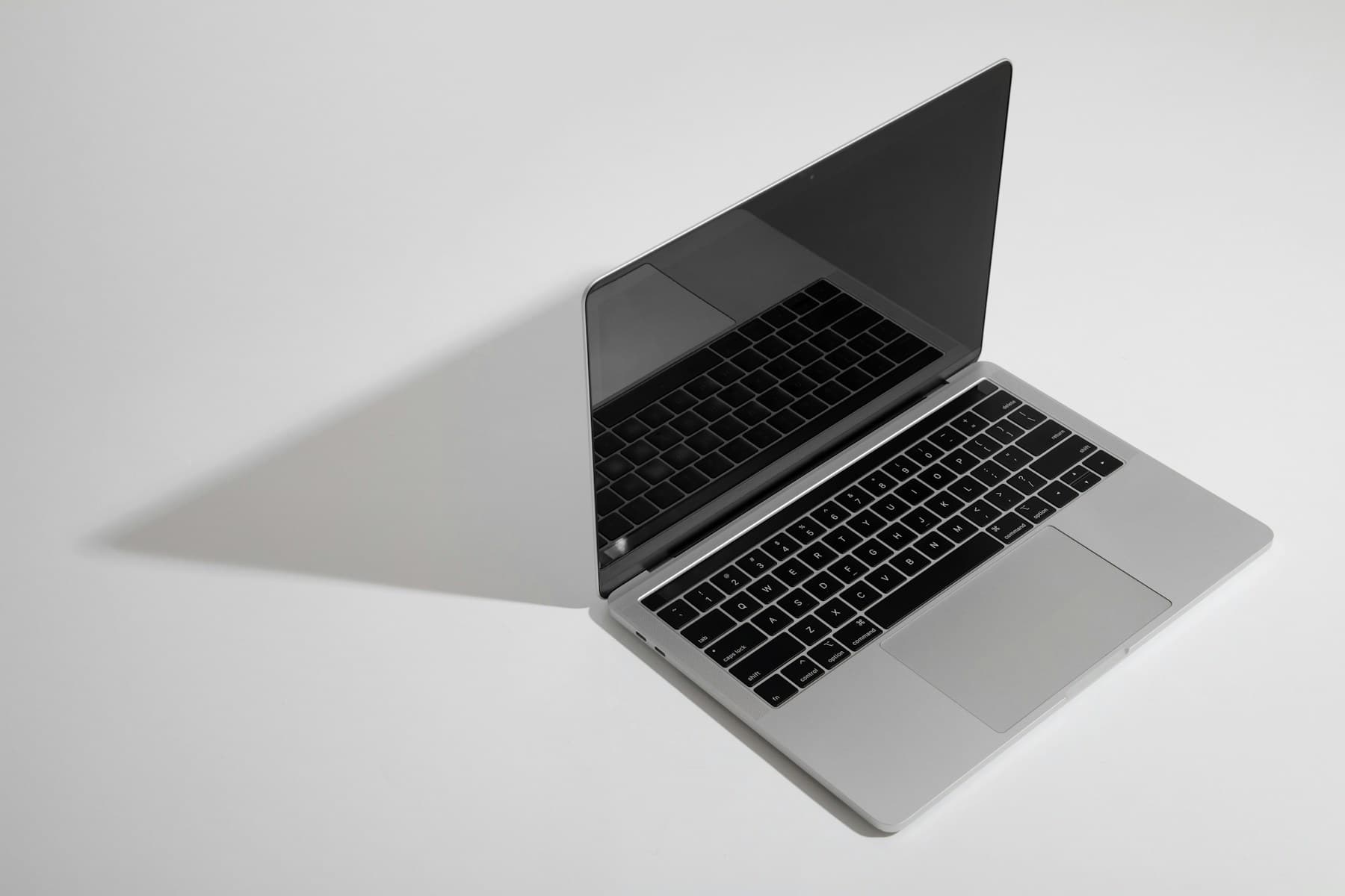 Laptop mockup with a dark screen on a light desk